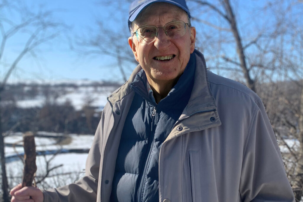 Jim Kackley posing in front of the snow-covered BaseCamp grounds