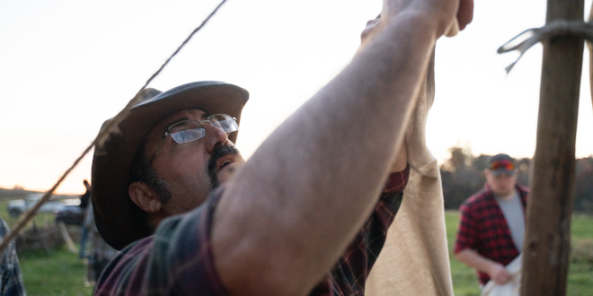 Man erecting a canvas tent