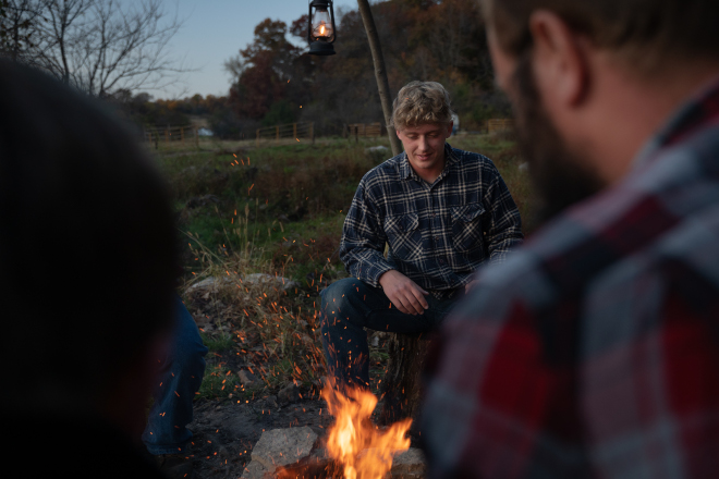 Man looking at a campfire