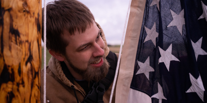 Man next to American flag