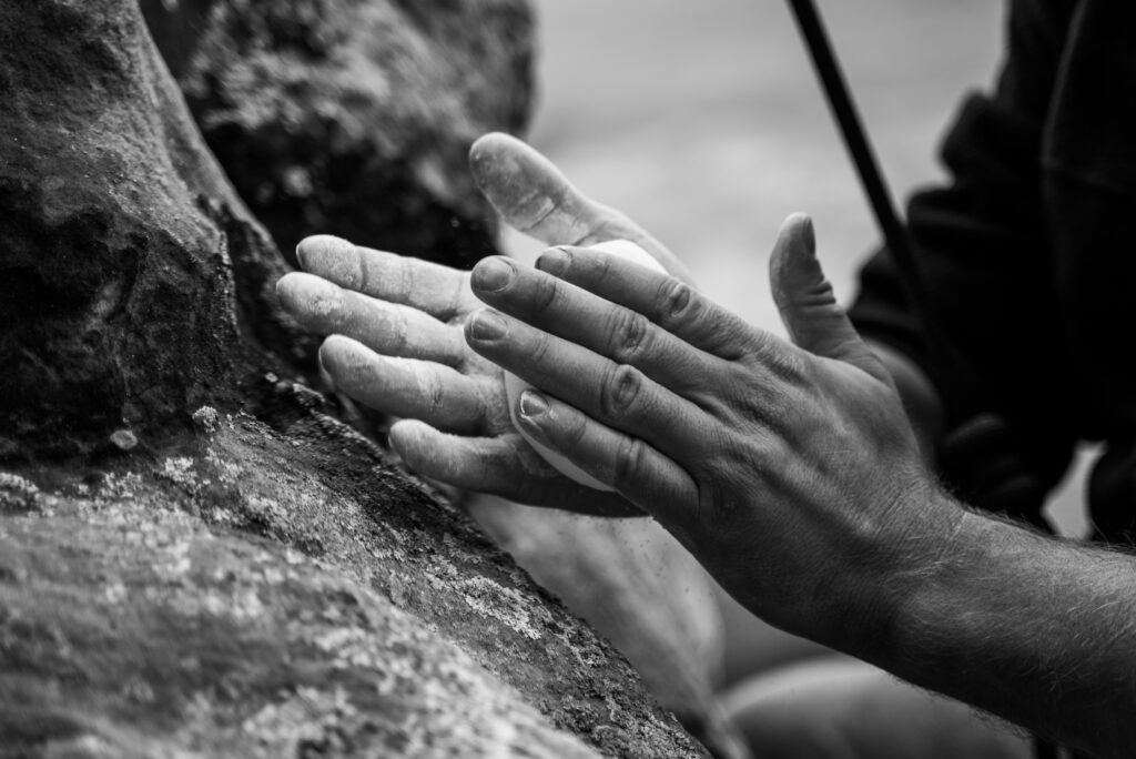 Man prepping hands with chalk for climbing