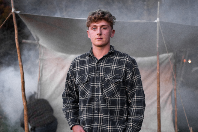 Young man in front of a tent