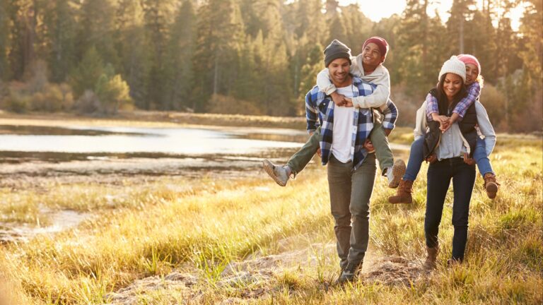 Father and Mother giving their children piggyback rides while on a hike