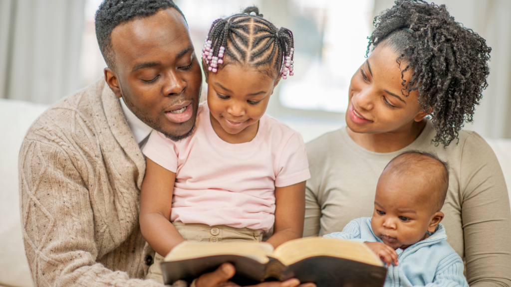 Man reading Bible to Wife and two children.